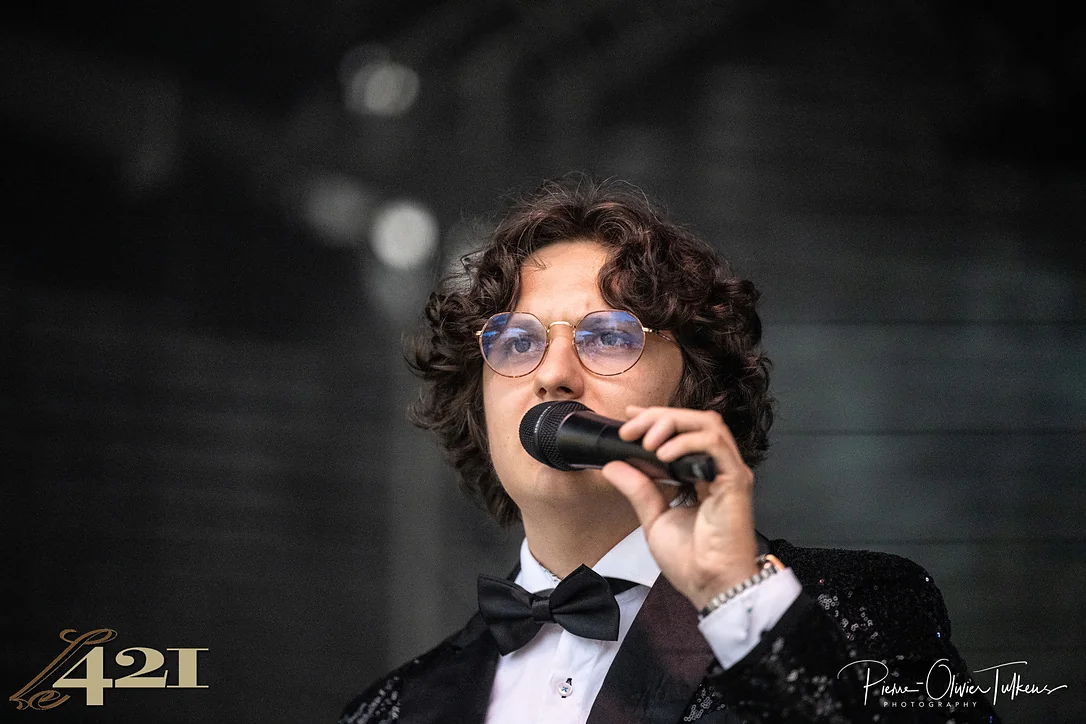 François Thiry au micro, en nœud papillon et veste à paillettes